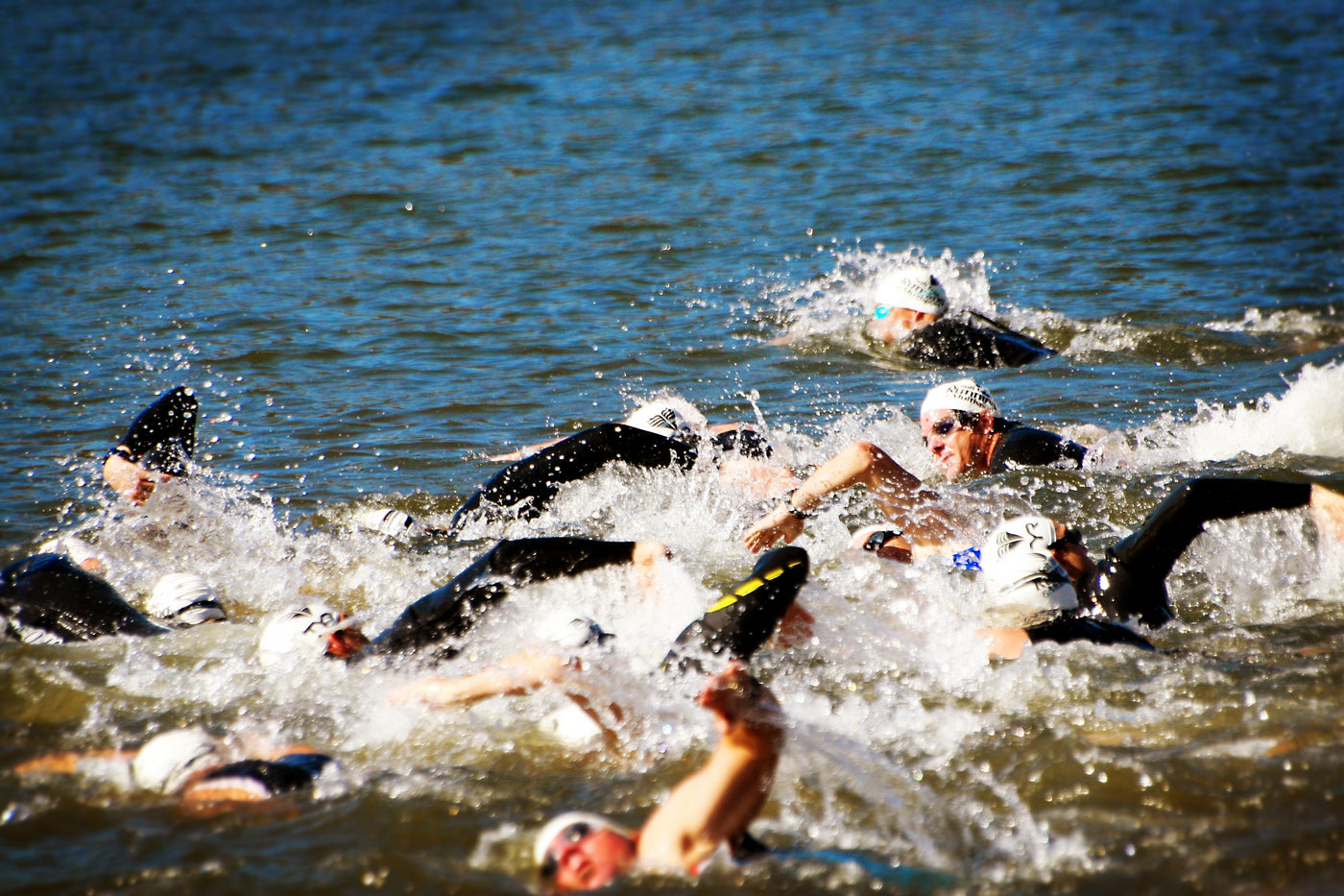 Group of triathletes swimming in open water during a triathlon race